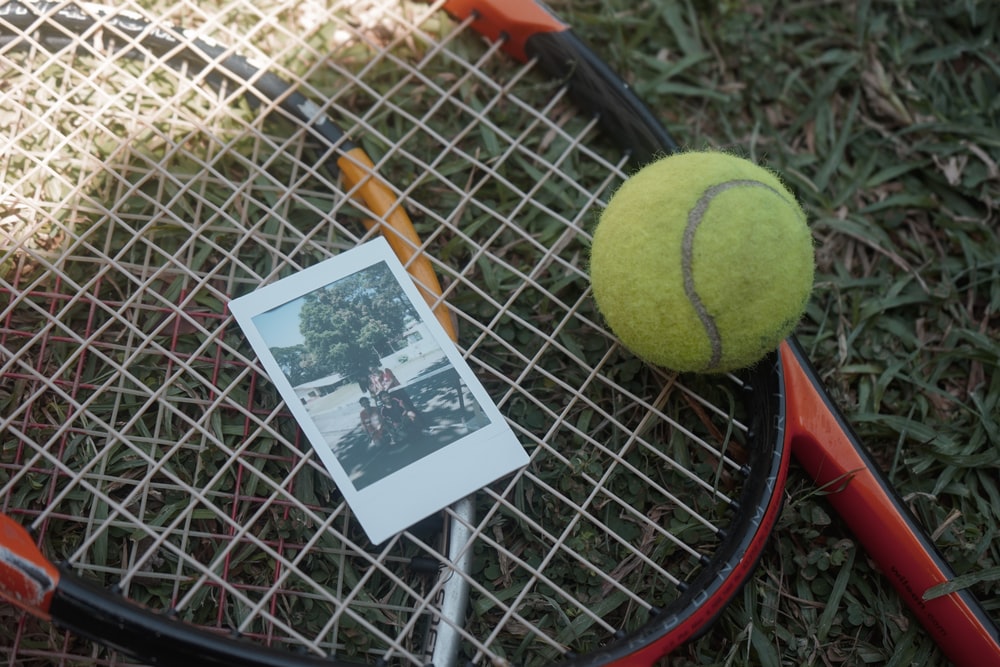green tennis ball beside white and black card